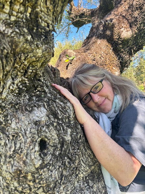 Person with glasses lying on an Olive Tree branch with a natural background
