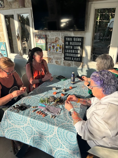 People sitting around a table with crafting items on it.