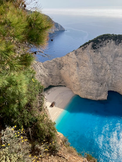 Scenic view looking down on enclosed bay with shipwreck on the beach