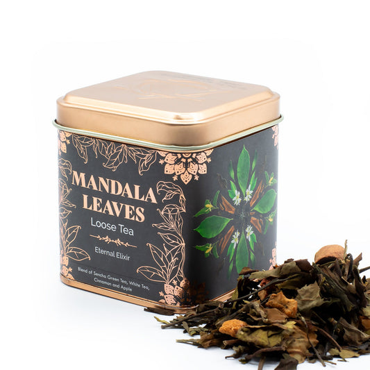 Black and gold tin of Mandala Leaves Eternal Elixir loose tea with green, white, and brown tea leaves.
