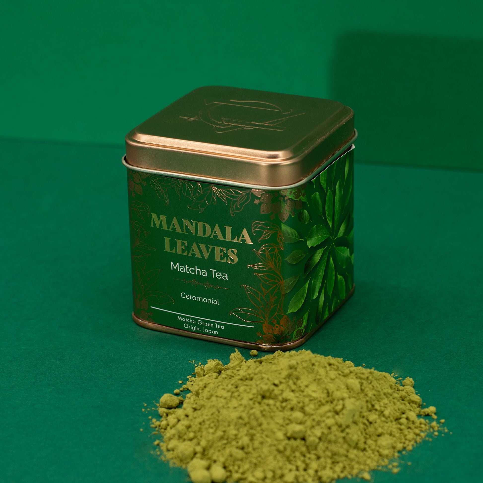 Mandala Leaves 50g ceremonial matcha tea in a green and gold tin with a pile of vibrant green matcha powder.