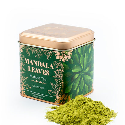 50g Mandala Leaves Ceremonial Matcha Tea in a square green and gold tin with a pile of vibrant green matcha powder.
